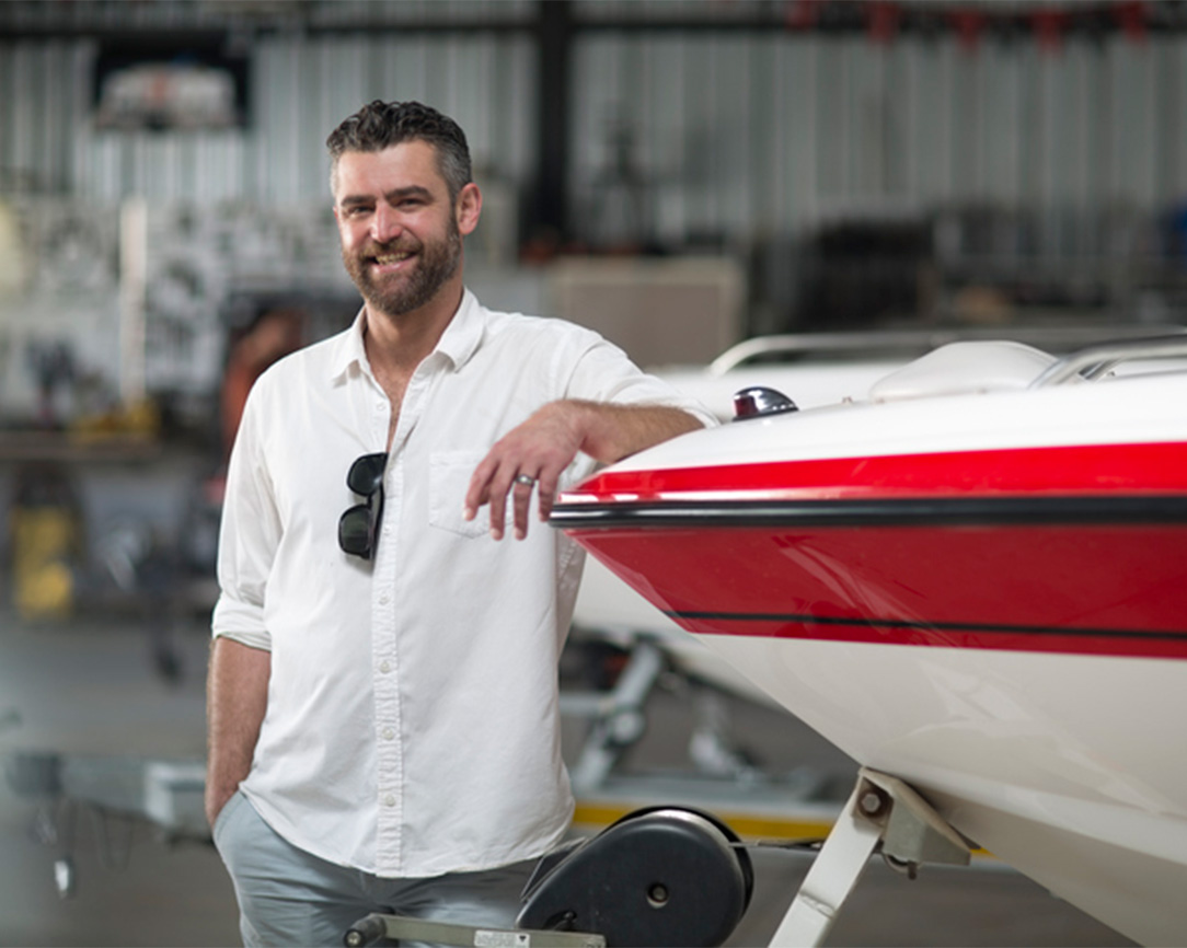 Man poserend naast trailer met boot